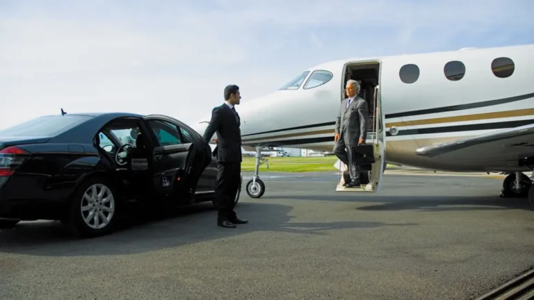 Luxury sedan providing private aviation transportation at an airport terminal.”